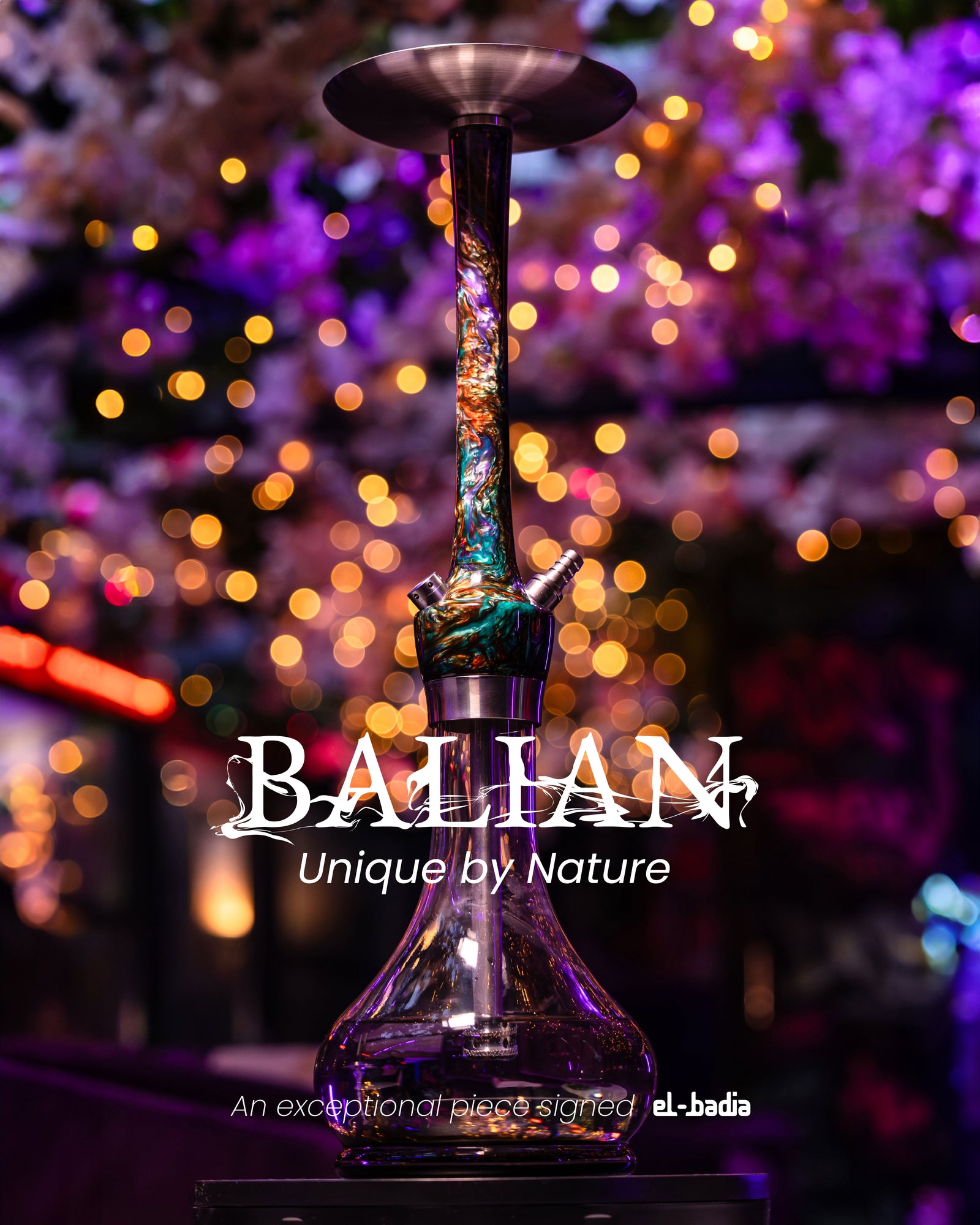 A sleek, modern hookah with a clear glass base and a colorful, marbled stem stands on a pedestal against a softly blurred background of warm, glowing lights and purple floral decor. Overlaid text reads “BALIAN – Unique by Nature” and “An exceptional piece signed el-badia.”